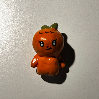 photo of a clay orange man with a leaf on his head