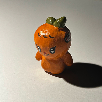 photo of a clay orange man with a leaf on his head